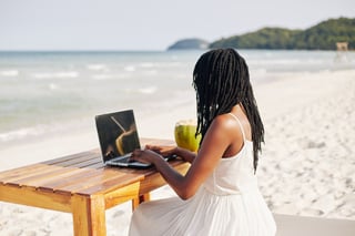 using her laptop to work remotely on beach.jpg
